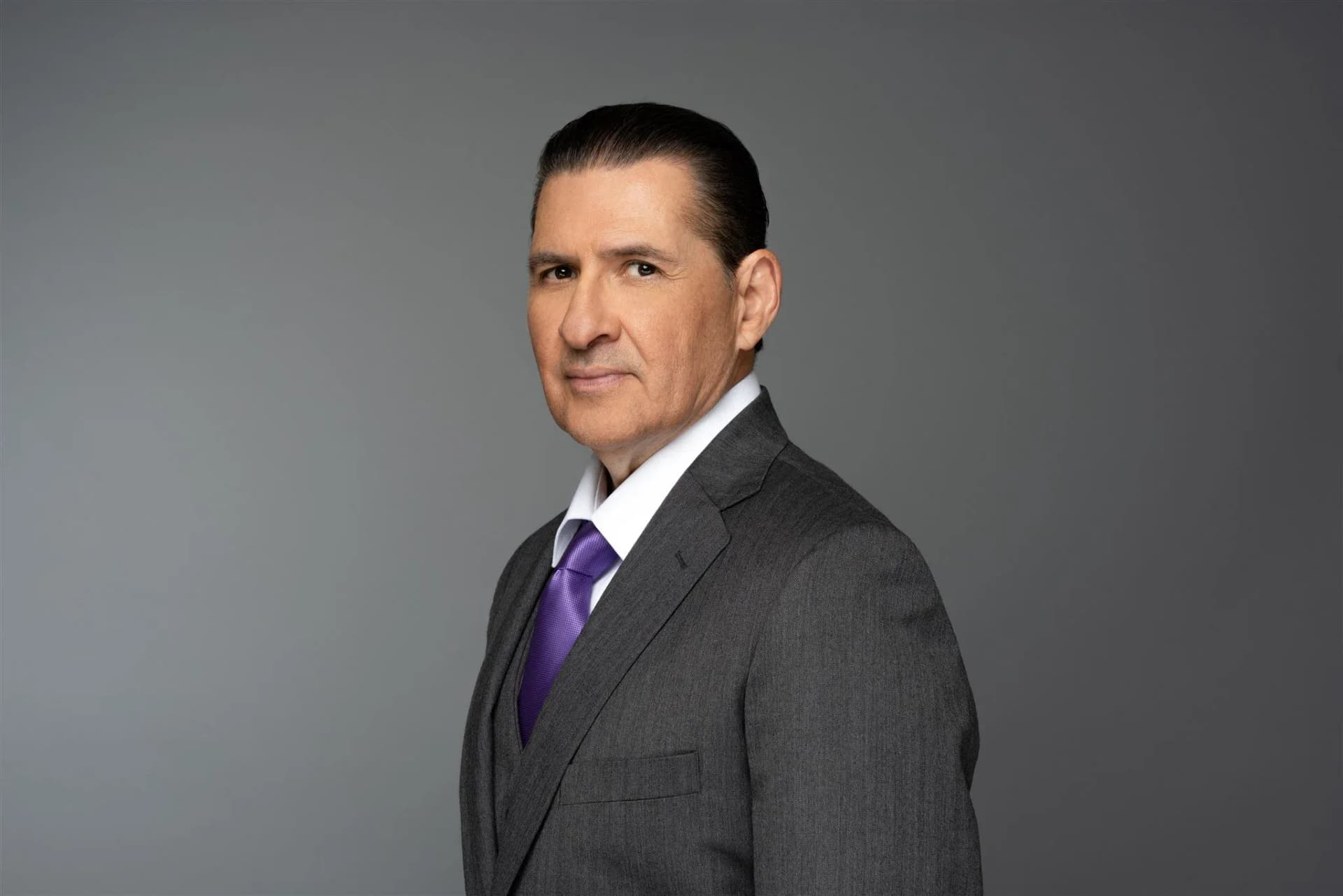 Classic studio headshot of a male executive in a gray suit