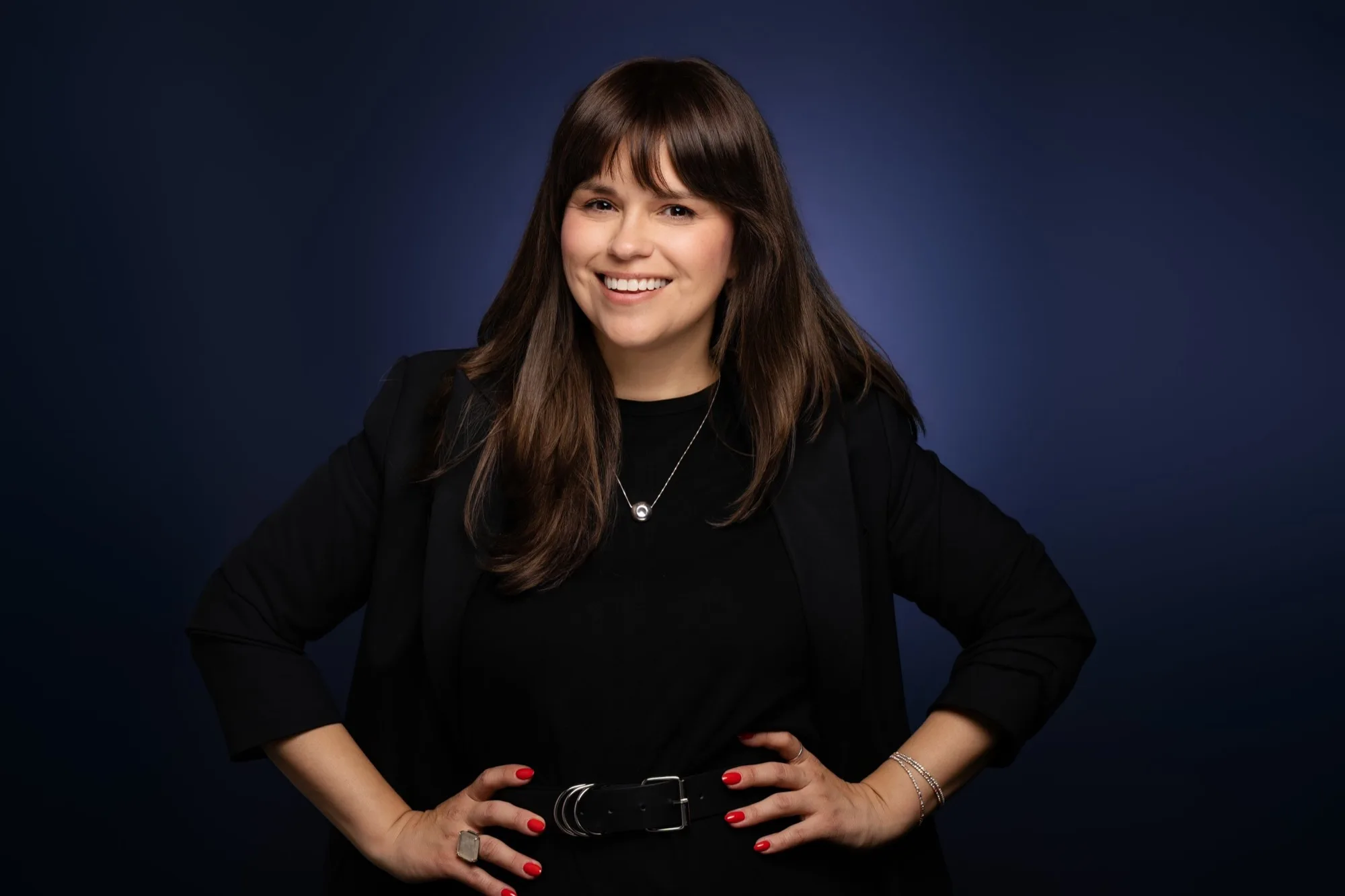Confident executive portrait against a deep blue studio background