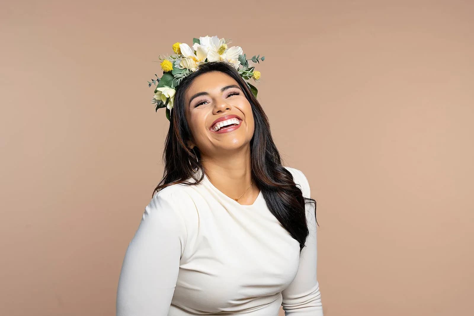 Personal brand portrait with a floral headpiece on a neutral backdrop